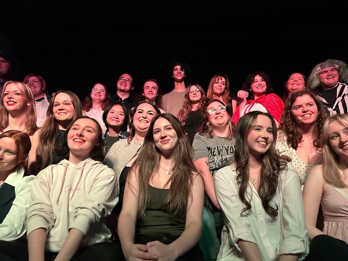 A large audience of young people, photo taken from below looking up into the stalls against a dark background.