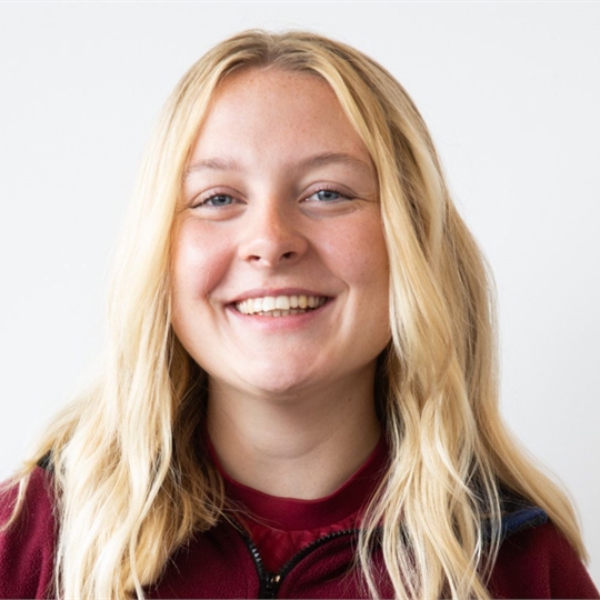 Person with long blonde hair smiling at the camera.
