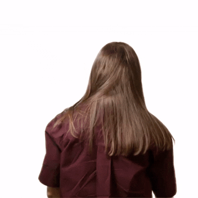 Moving image of person with shoulder length brown hair turning and folding their arms to the camera.
