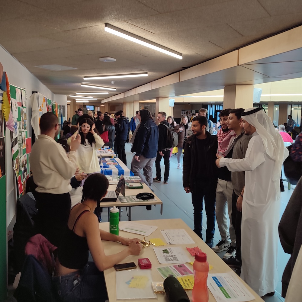 An event with people walking past tables of students' union opportunities.