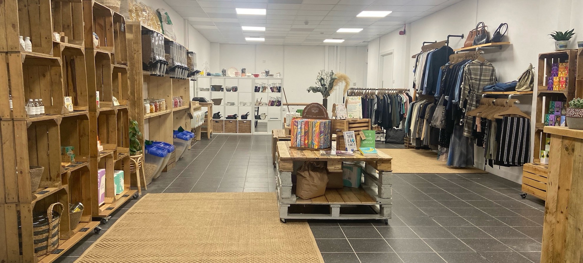 The inside of a sustainable living store, there are several shelves with eco products on display.