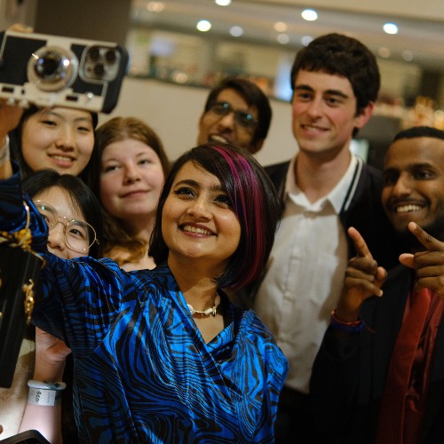Group of young people taking a selfie together, they are all dressed smartly.